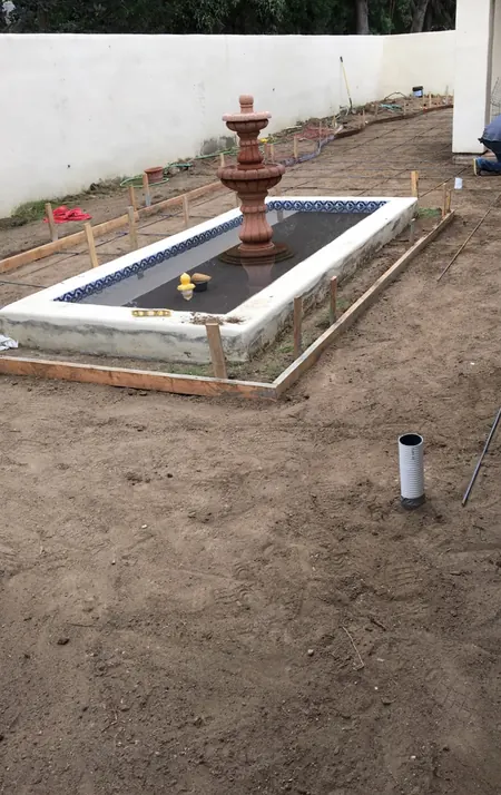 Before: bare dirt yard with the fountain basin framed out