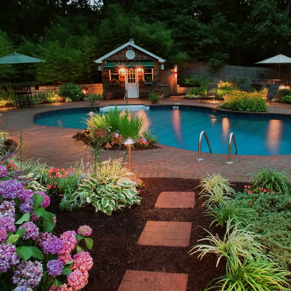 Pool garden at dusk with hydrangeas and stepping stones